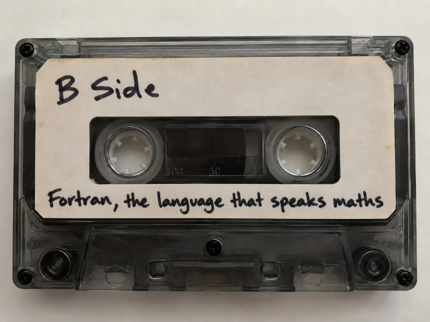 A cassette tape with a handwritten label: "B Side. Fortran, the language that speaks maths."